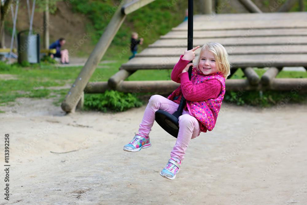 Little girl having fun at playground. Happy cute child, blond sportive toddler girl in casual outfit, playing in the park on a sunny day. Leisure outdoors activity with children. Little girl having fun at playground. Happy cute child, blond sportive toddler girl in casual outfit, playing in the park on a sunny day. Leisure outdoors activity with children.