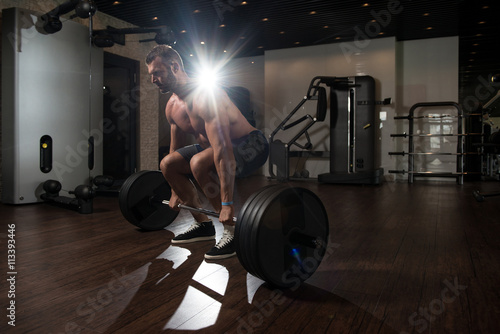 Man In The Gym Exercising Back With Barbell
