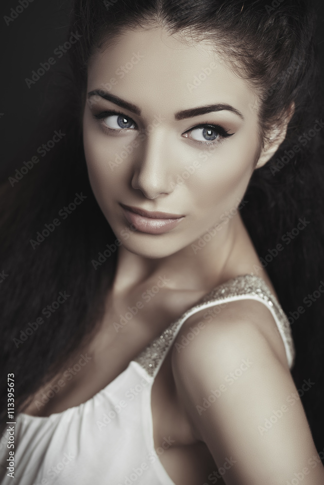 Portrait of attractive brunette young woman with blue eyes, healthy skin, looking sideways. Toned color. Portrait of attractive brunette young woman with blue eyes, healthy skin, looking sideways. Toned color.