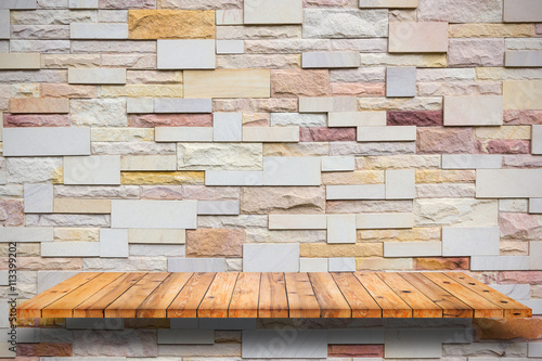 Empty wooden shelves and stone wall background.
