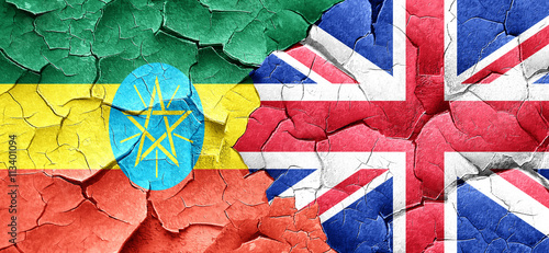 Ethiopia flag with Great Britain flag on a grunge cracked wall