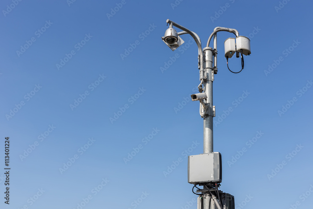 Security CCTV camera operating on the road and blue sky backgrou Security CCTV camera operating on the road and blue sky backgrou