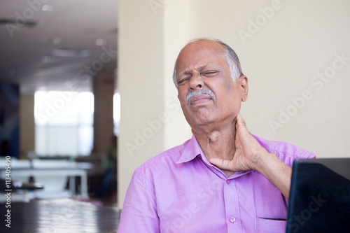 Obraz na plátne Closeup portrait, elderly gentleman in pink shirt with cramping neck pain after