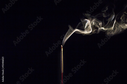 Incense Stick with Smoke on Black in black and white abstract background.