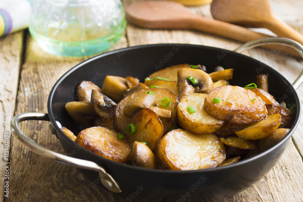 Fried potatoes with mushrooms in a frying pan Fried potatoes with mushrooms in a frying pan