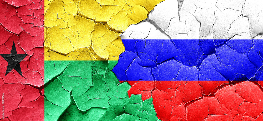 Guinea bissau flag with Russia flag on a grunge cracked wall