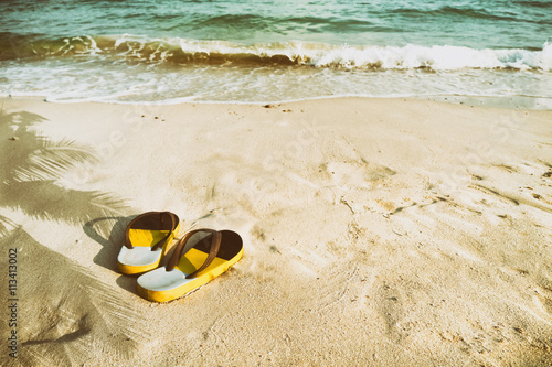 retro slippers on tropical beach in summer - vintage color tone effect