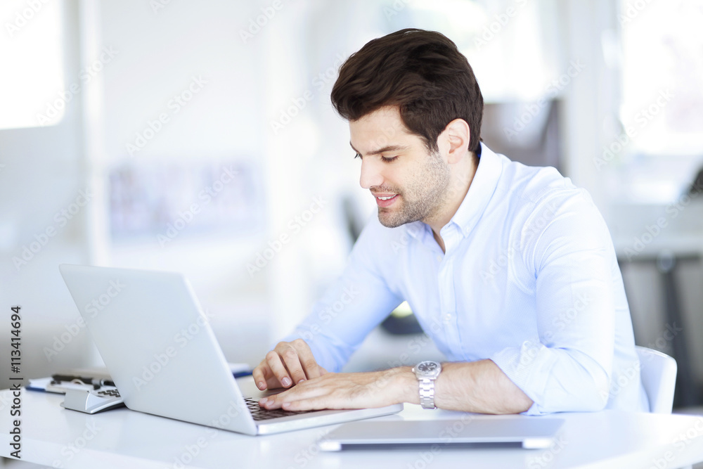 Solve the problem. Young businessman working on the solution of the problems on laptop at office Solve the problem. Young businessman working on the solution of the problems on laptop at office