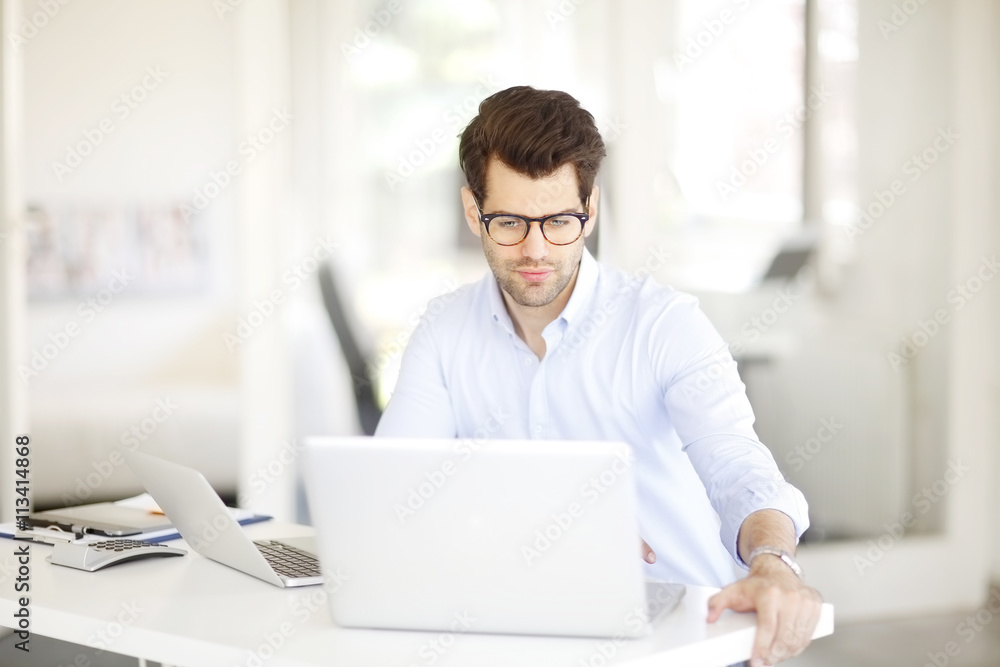 Solve the problem. Young businessman working on solving the problem on laptop at office. Solve the problem. Young businessman working on solving the problem on laptop at office.