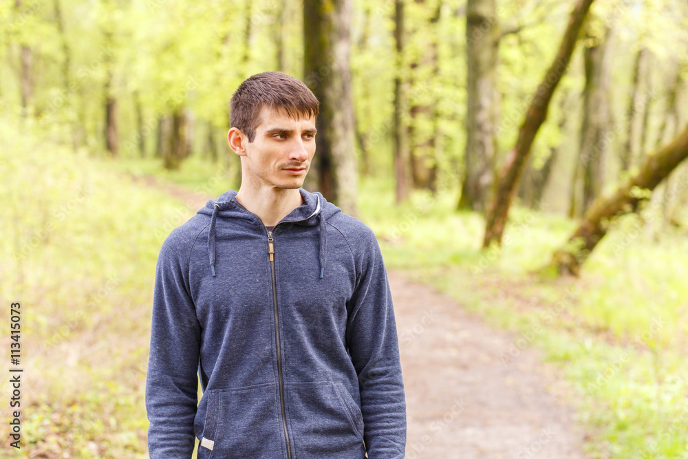 Young sportsman standing on trail after jogging Young sportsman standing on trail after jogging