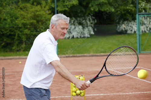 Win the game. Senior trainer man playing tennis © sepy