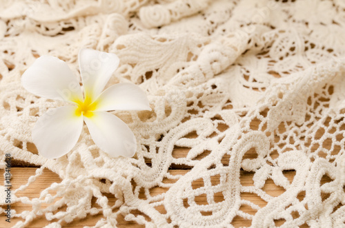 Flower with lace on wooden background. Place for text.