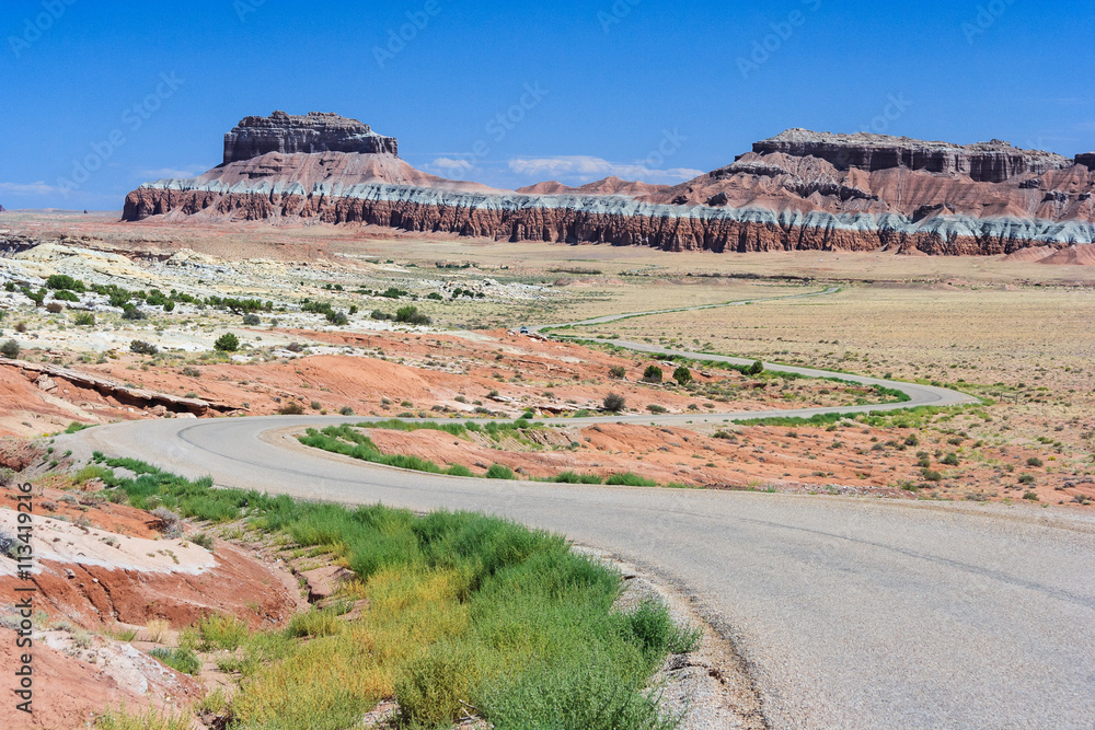 Highway running through colorful painted desert in central Utah near Canyonland, Zion, Bryce and Goblin  Valley