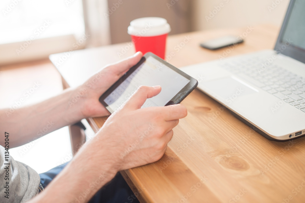 Fototapeta premium Workplace. Hands holding tablet and notebook closeup