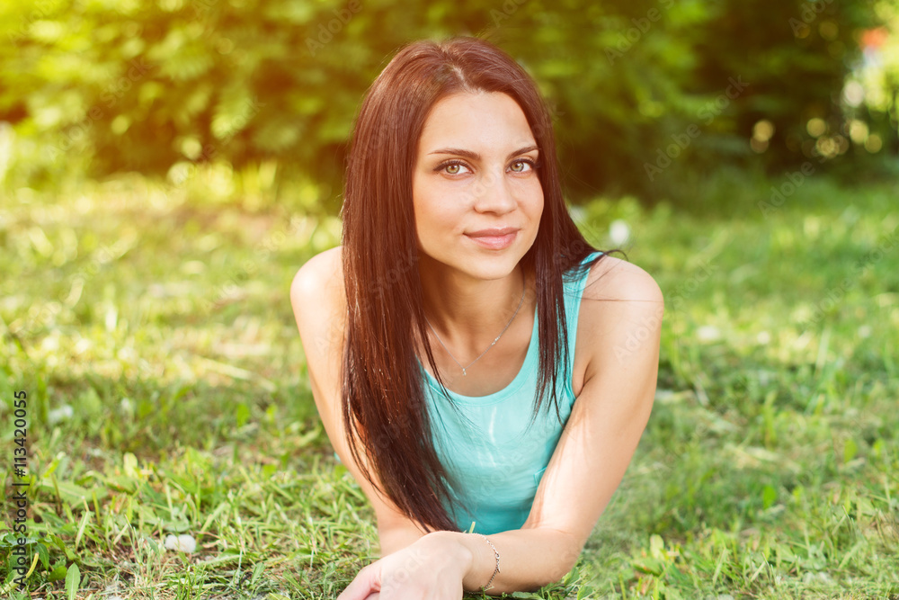 Beautiful woman relaxing outdoors on grass looking happy and smiling. Beautiful woman relaxing outdoors on grass looking happy and smiling.