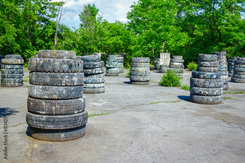 Abandoned paintball playground with barricades made of old tires with paint marks after fights