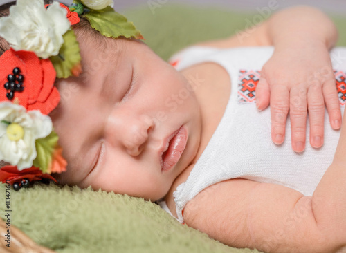 newborn girl in Ukrainian costume sleeping close-up