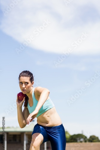 Fototapeta Naklejka Na Ścianę i Meble -  Female athlete preparing to throw shot put ball