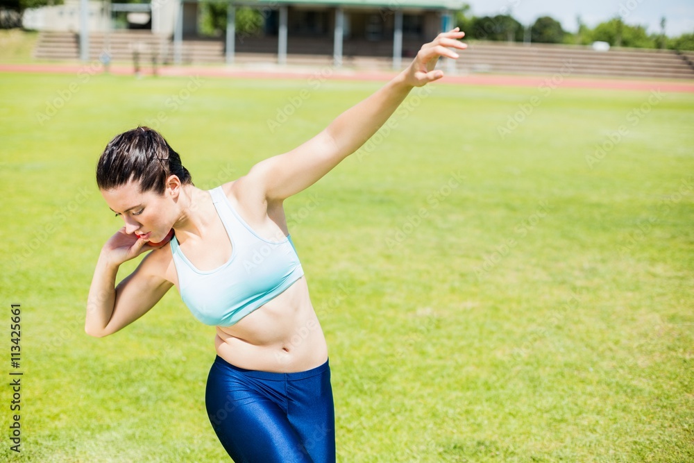 Female athlete preparing to throw shot put ball Female athlete preparing to throw shot put ball