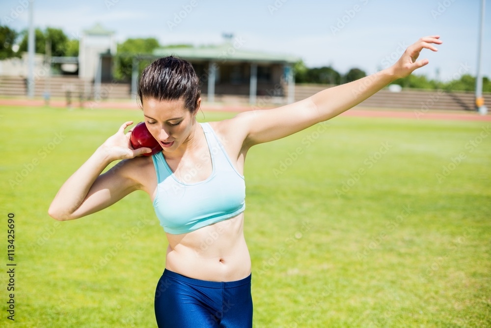 Female athlete preparing to throw shot put ball Female athlete preparing to throw shot put ball