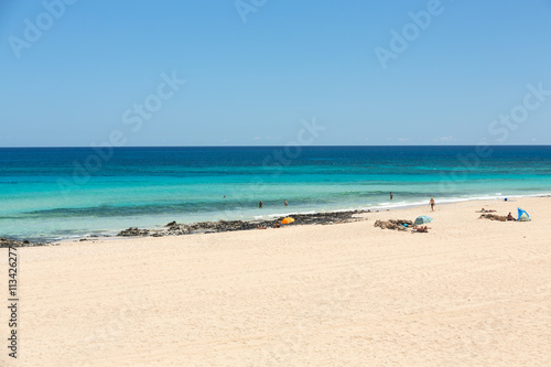 Tourists rest on Corralejo Beach on Fuerteventura, Canary Islands © wjarek