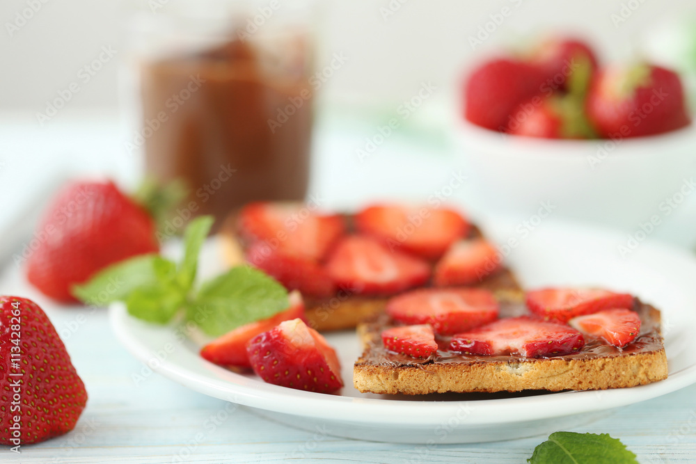 French toasts with chocolate and strawberry on wooden table French toasts with chocolate and strawberry on wooden table