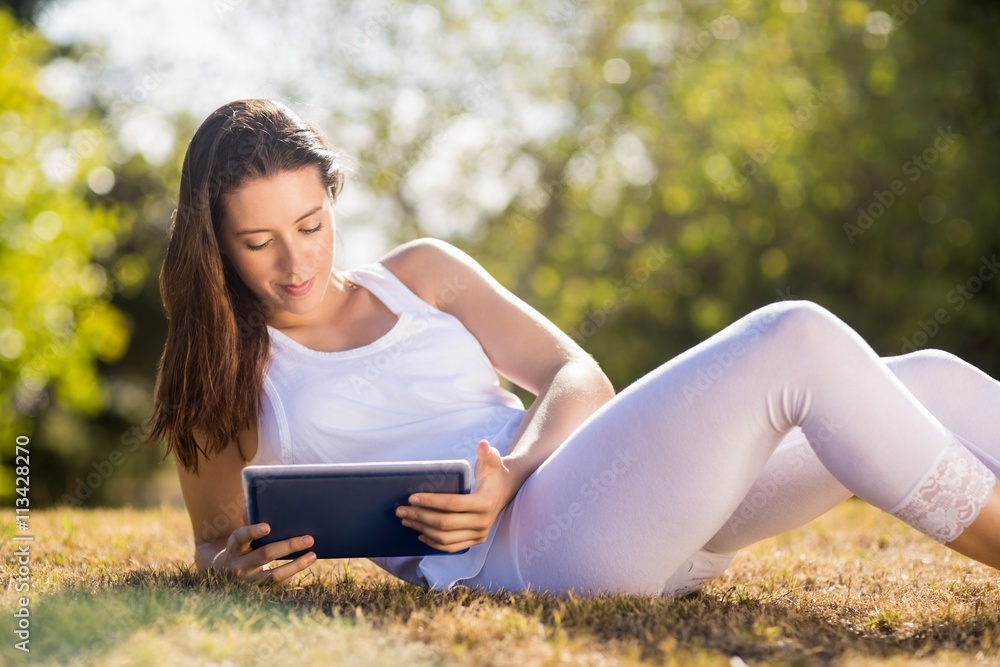 Woman sitting on grass and using digital tablet Woman sitting on grass and using digital tablet
