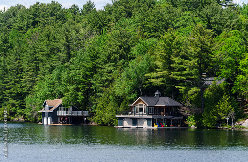 Billede på lærred Two boathouses on a lake in Muskoka, Ontario