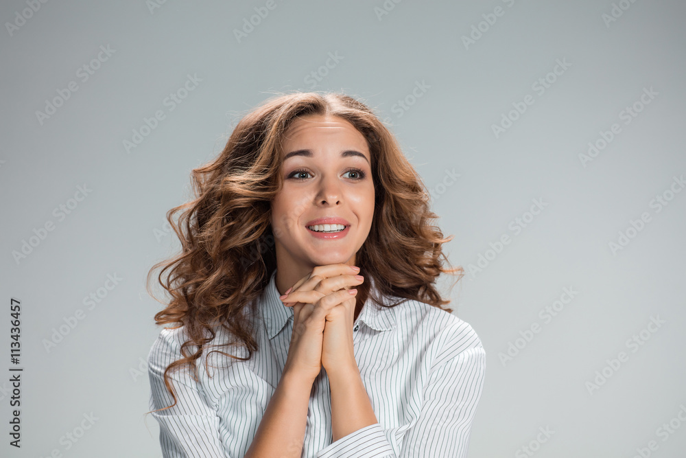 Woman is looking imploring over gray background Woman is looking imploring over gray background