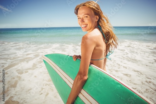 Woman holding surfboard on beach © WavebreakMediaMicro