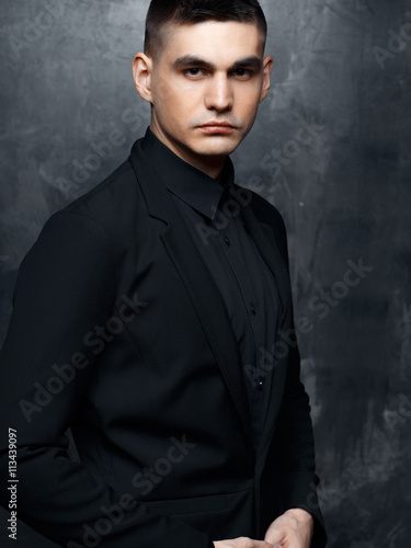 Portrait of handsome man in a black suit. © cherry_d