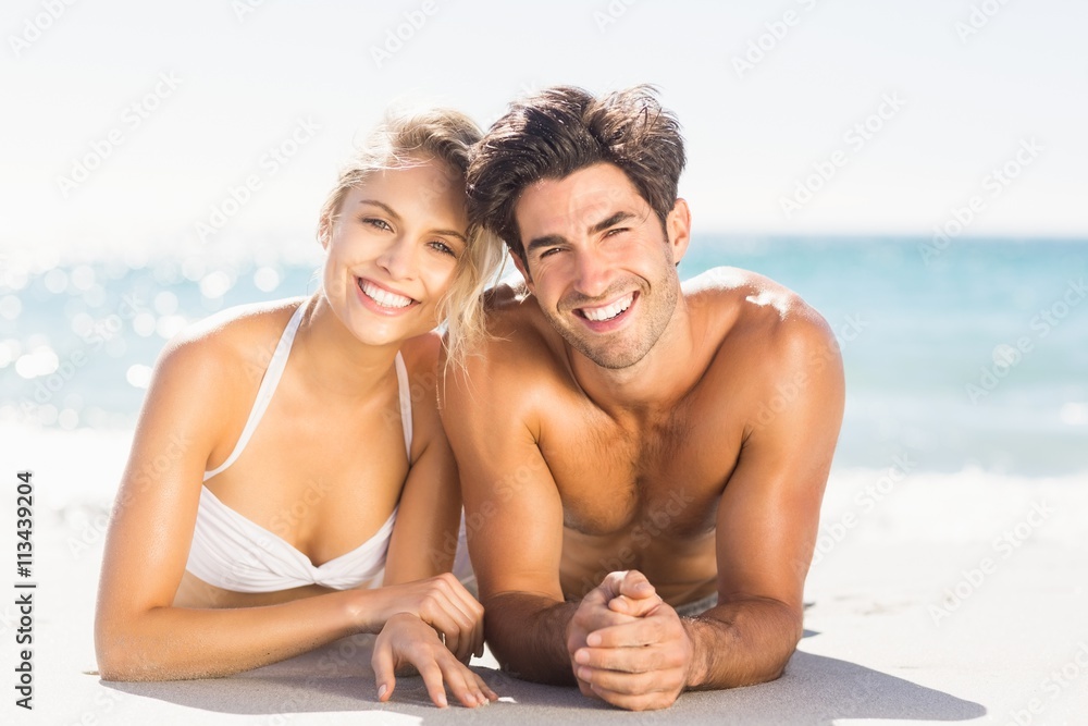 Fototapeta premium Young couple lying on beach