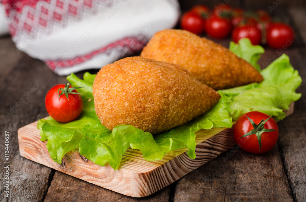 Chicken cutlets in breadcrumbs - Chicken Kiev on wood board and wooden background. Ukrainian cuisine. Selective focus Chicken cutlets in breadcrumbs - Chicken Kiev on wood board and wooden background. Ukrainian cuisine. Selective focus