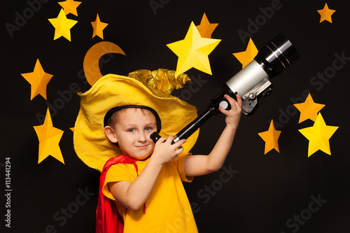 Little sky watcher looking through a telescope photo