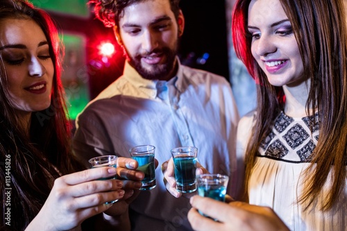 Group of friends toasting tequila shot glasses