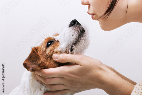 Young girl holding and kissing his dog Jack Russell Terrier. Positive human emotions, facial expression, feelings