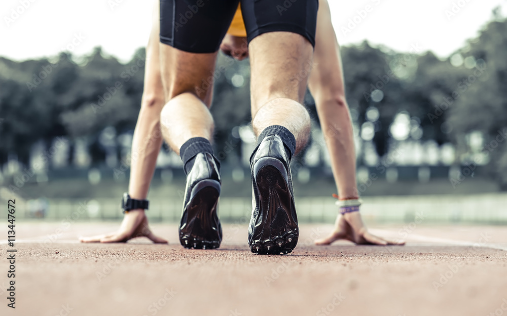 Fototapeta premium Professional male runner taking ready to start position