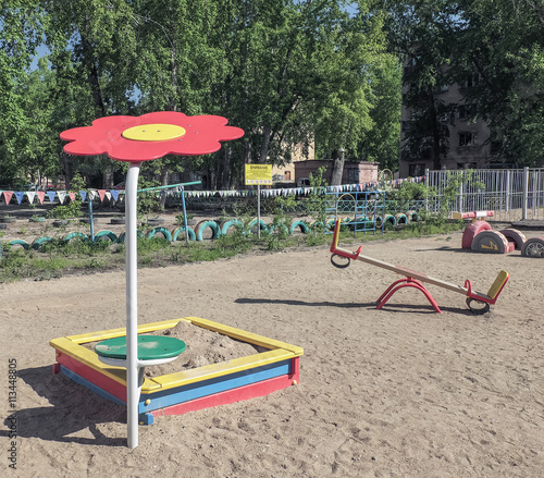 Children's playground in the sand . Sandbox and canopy in the form of daisies . Swing