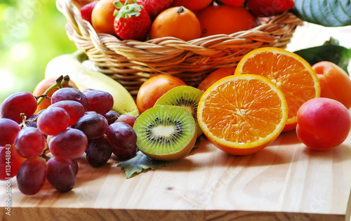 half orange  sliced kiwi  other fruits in the basket