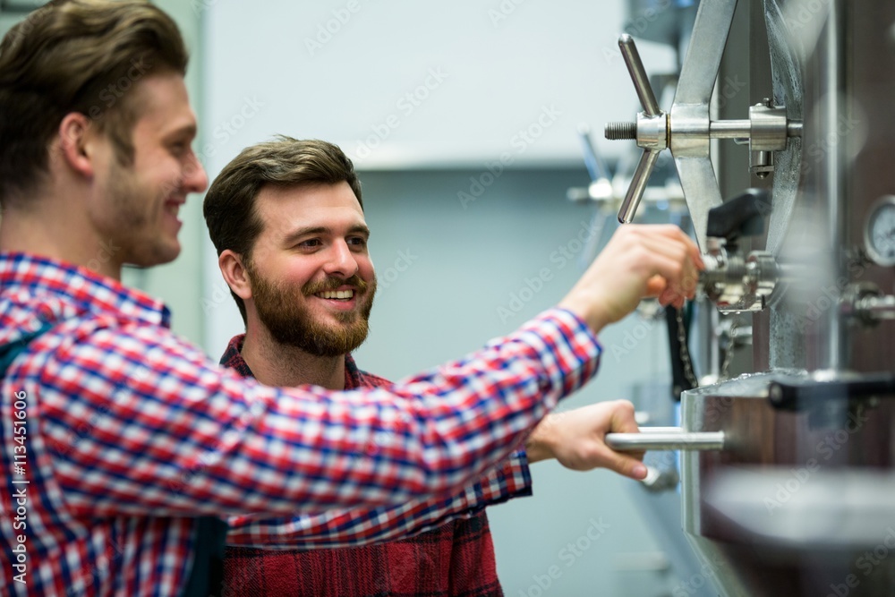 Obraz premium Maintenance workers examining brewery machine