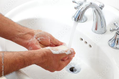 Man washing hands with soap and water.