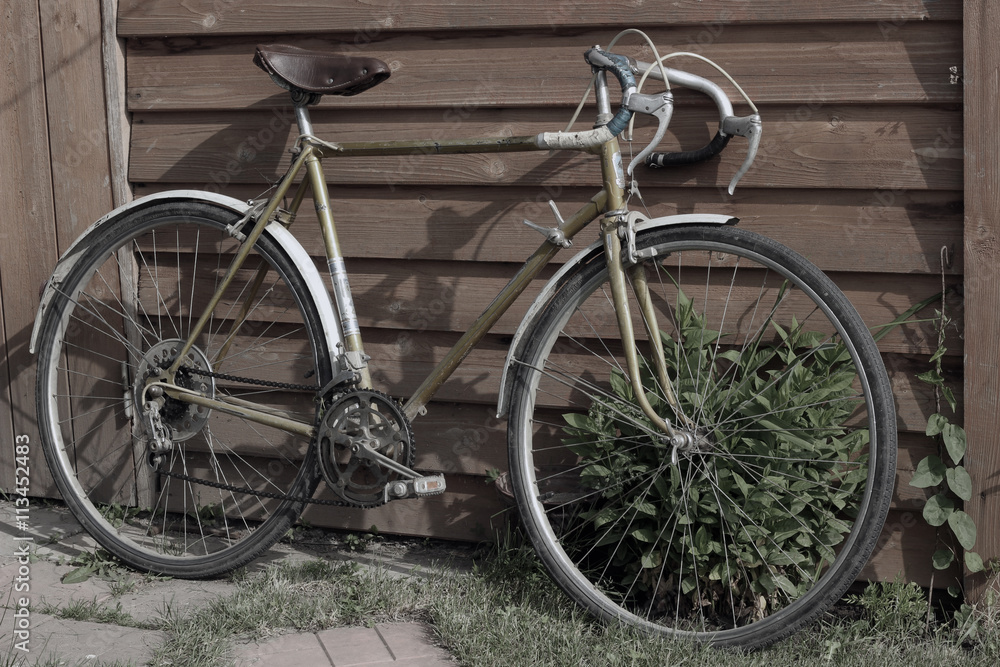 Old vintage bike. Retro road bicycle standing at the wooden wall