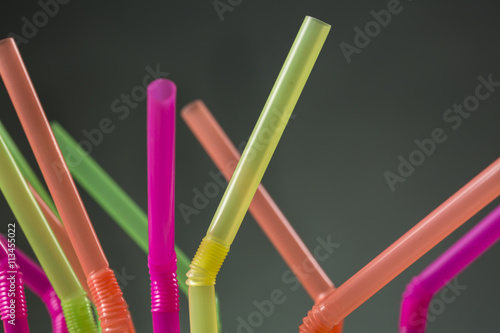 Close-up of articulated drinking straws of colors yellow, pink, orange and green photo