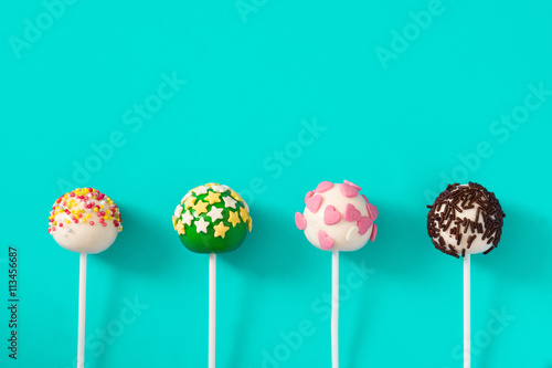 Colorful cake pops on blue background