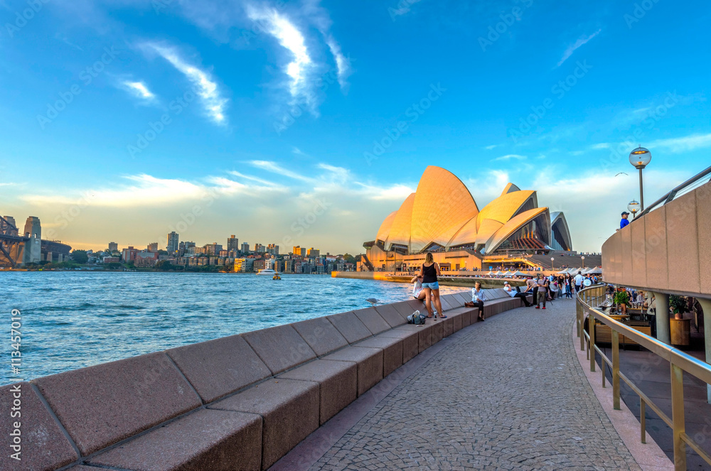 Fototapeta premium Turyści spacerujący obok baru operowego przed Sydney Opera Hous