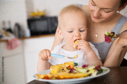 Mother and child eating together and have fun