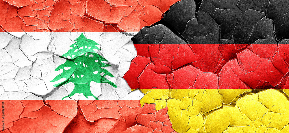 Lebanon flag with Germany flag on a grunge cracked wall