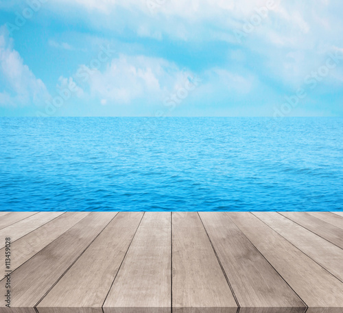 Wood table top on blue sea and sky background

