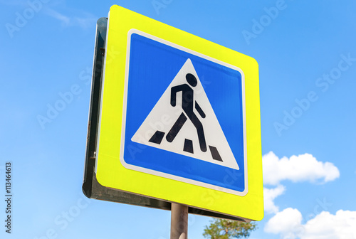 Traffic sign pedestrian crossing with blue sky in background