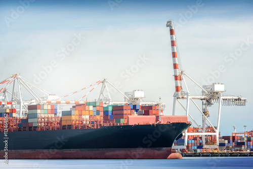 International Transportation Shipping, Container Cargo freight ship with ports crane bridge in harbor, Logistic Import Export background concept, un-mooring of containers cargo ship.